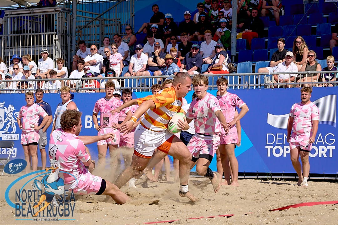 Men competing in an intense rugby match Men competing in an intense rugby match on a sunny beach setting The Hague Beach Stadium